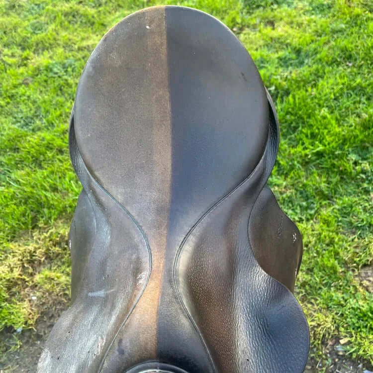 Close-up of a well-worn horse saddle bottom, showcasing the leather's natural texture and sheen.