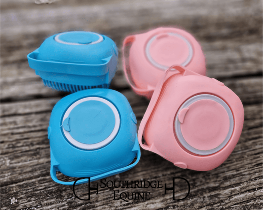 Colorful SE Sudsy Scrubber bottles in blue and pink stacked on a wooden surface, ideal for messy bath days.